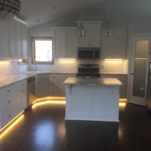 Custom white enameled  cabinets kitchen remodel with new hardwood floors and granite counter tops in Eagan